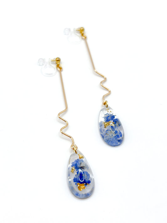 Teardrop-shaped earrings with floral design on a white background