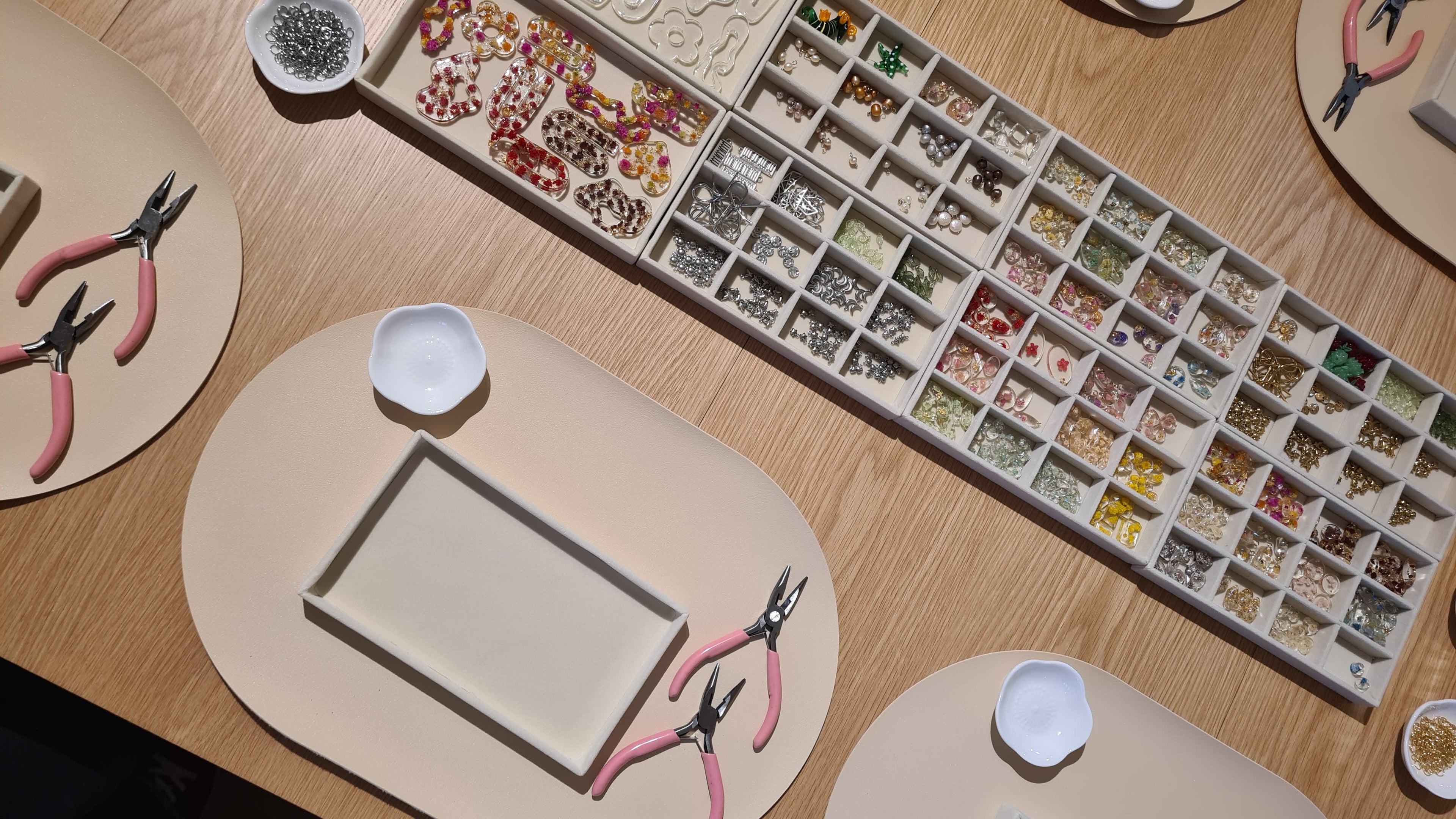 Trays with jewelry charms containing real flowers for custom jewelry making