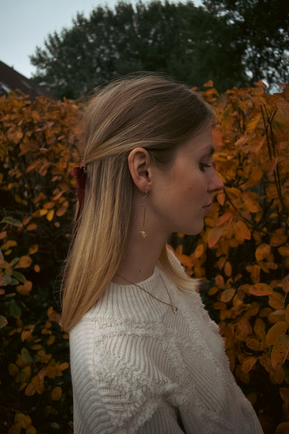 Woman wearing a white sweater with autumn foliage in the background