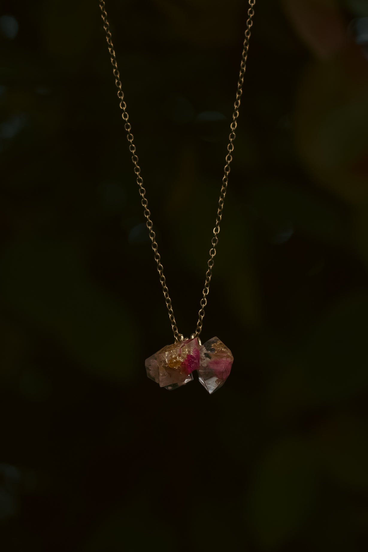 Necklace with two pink gemstones on a dark background