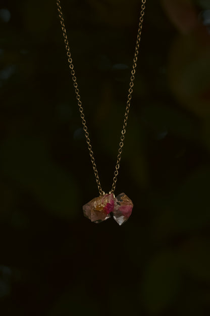 Necklace with two pink gemstones on a dark background