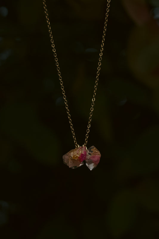 Necklace with two pink gemstones on a dark background