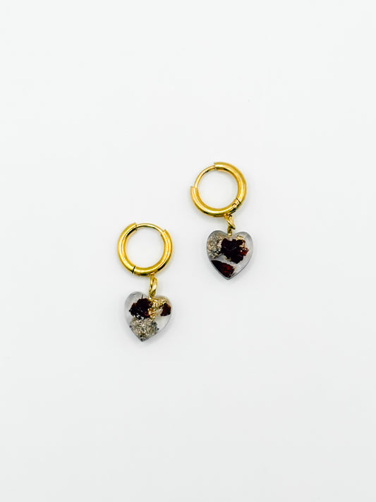 Heart-shaped earrings with gold loops on a white background