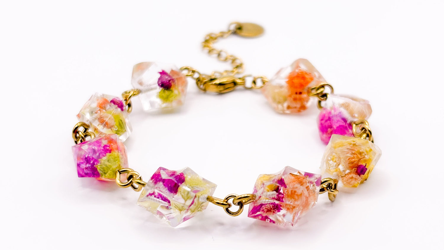 Colorful floral bracelet with gold accents on a white background