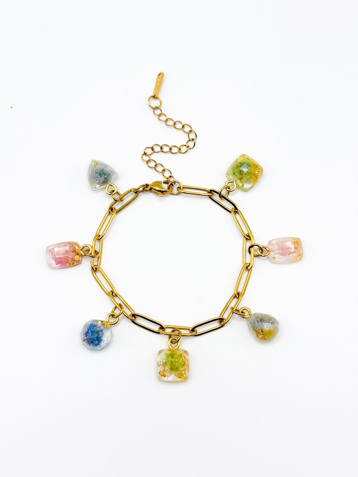 Gold bracelet with colorful gemstone charms on a white background