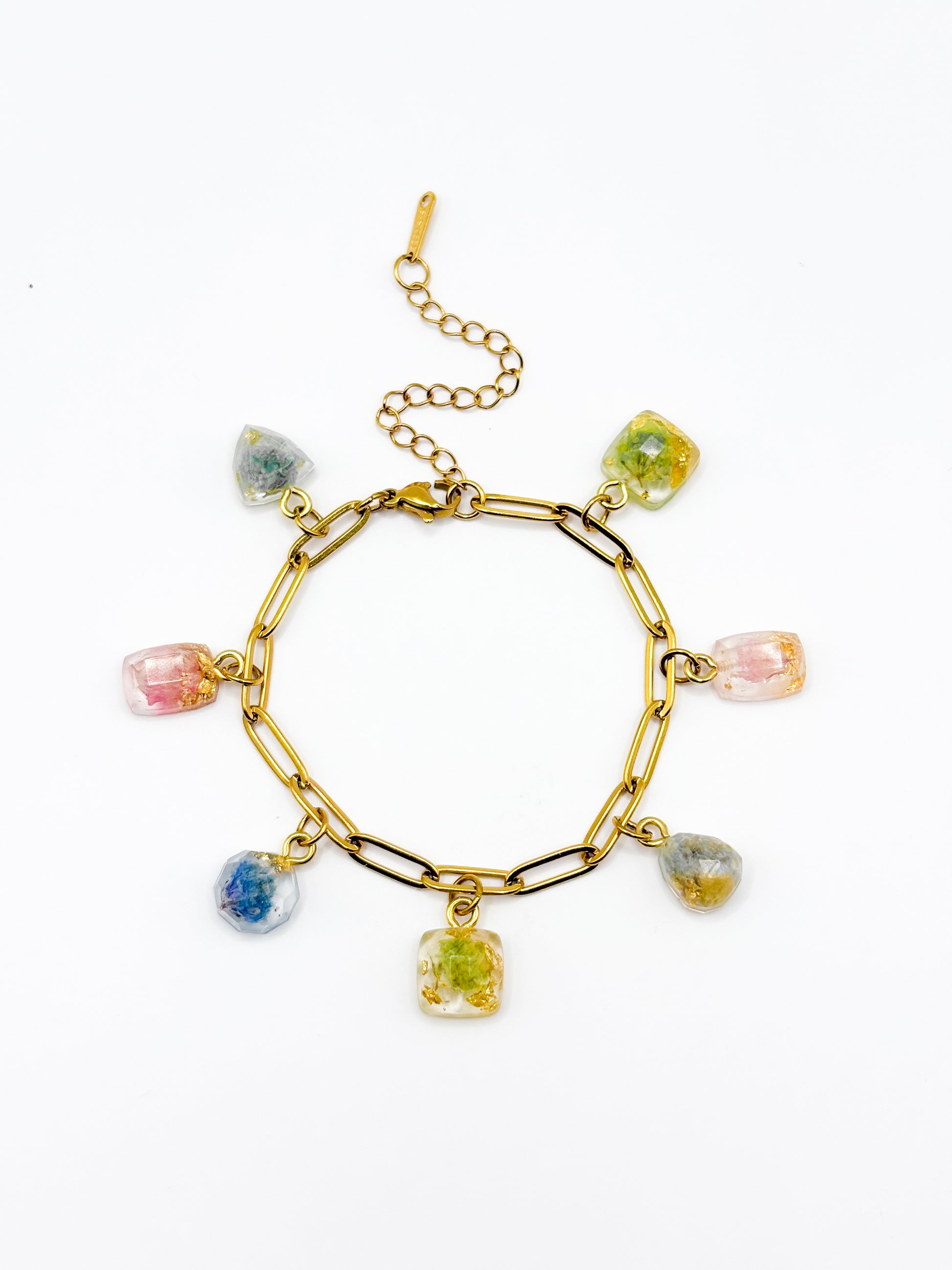 Gold bracelet with colorful gemstone charms on a white background