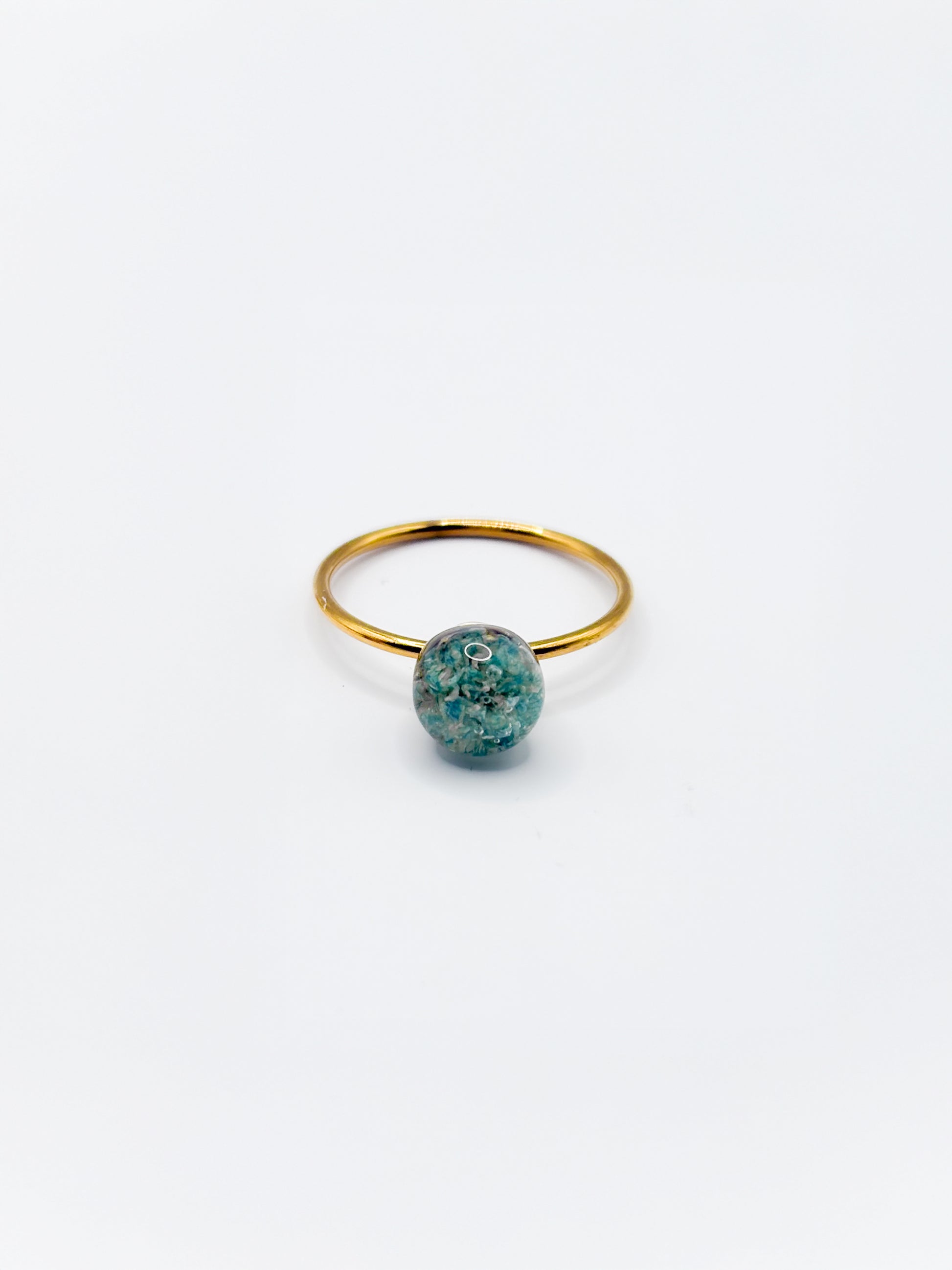 Gold ring with a turquoise gemstone on a white background