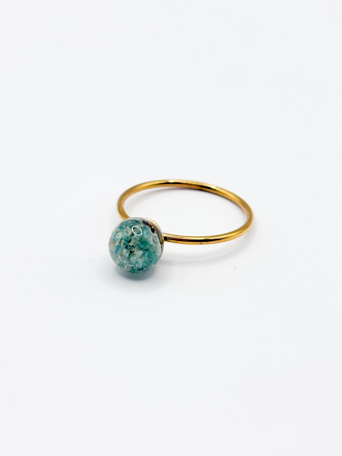 Gold ring with a turquoise gemstone on a white background