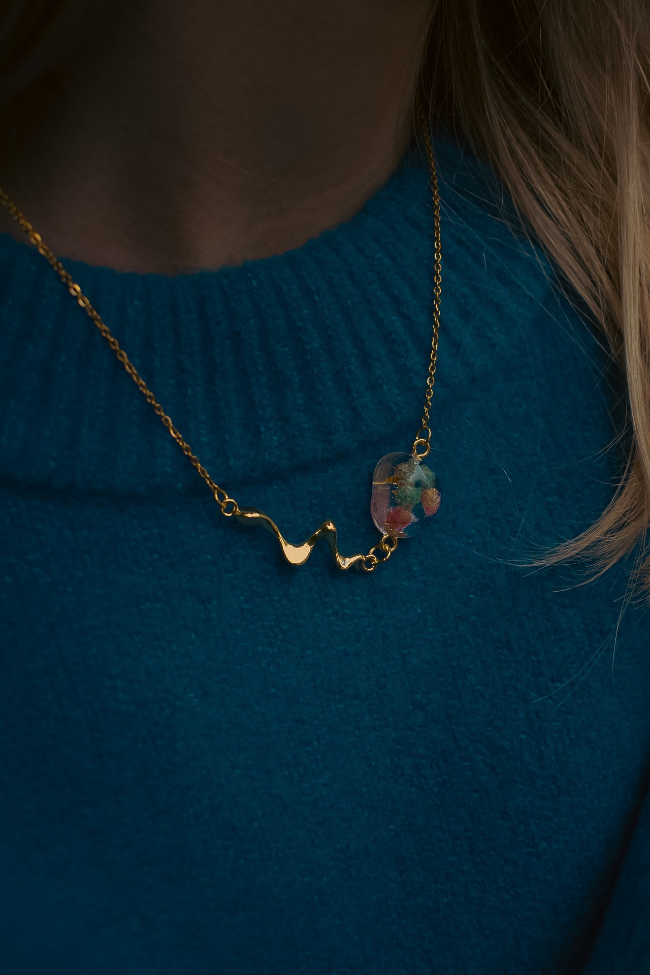 Late Bloomers Liquid Pebble Necklace with real flowers zoomed on blue sweater