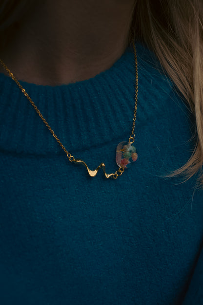 Late Bloomers Liquid Pebble Necklace with real flowers zoomed on blue sweater