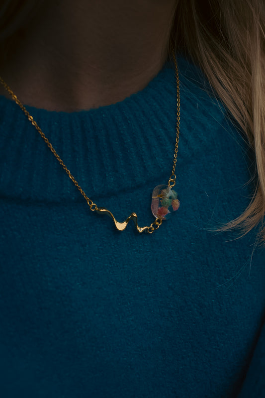 Late Bloomers Liquid Pebble Necklace with real flowers zoomed on blue sweater