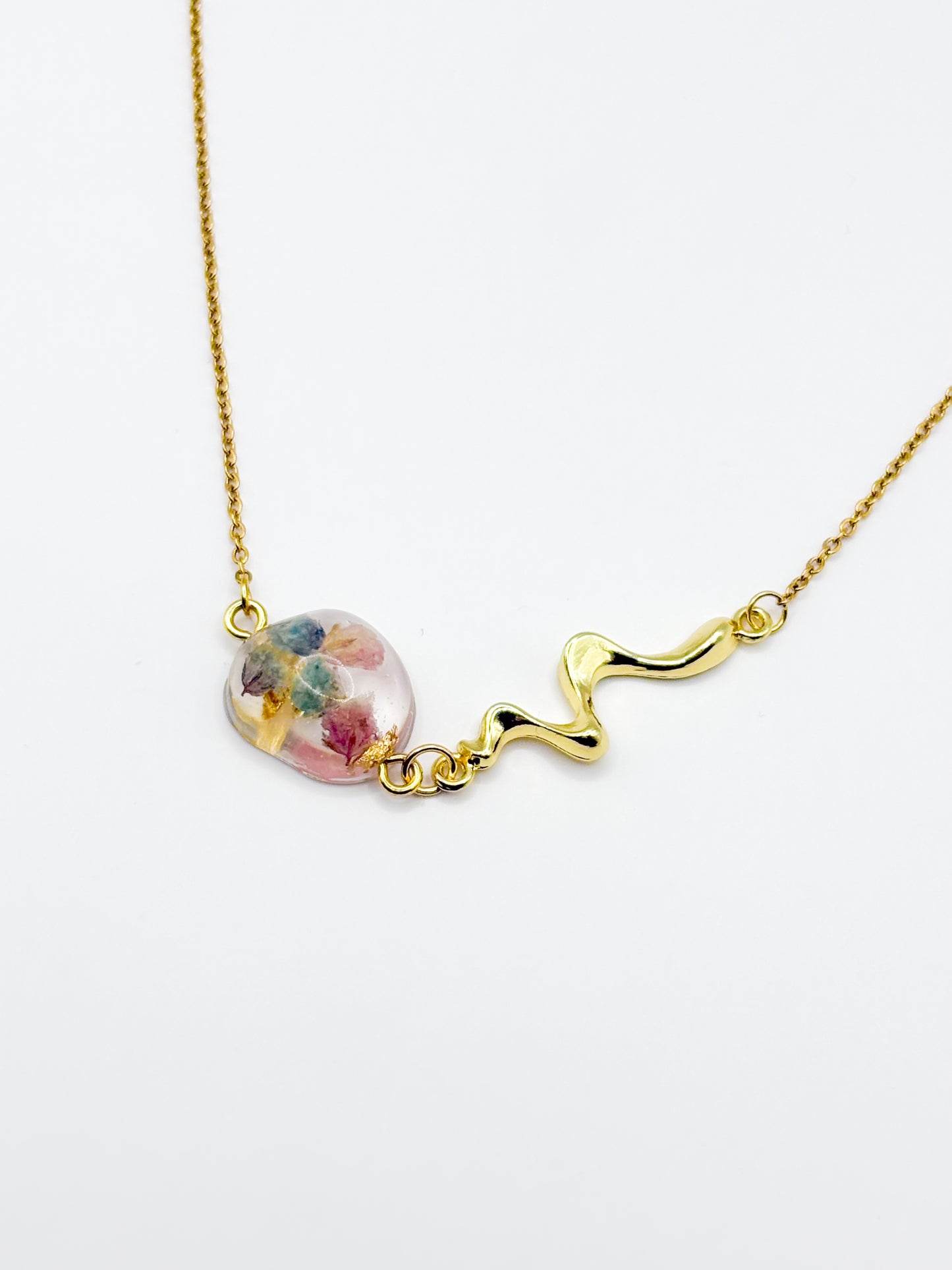 Gold necklace with a floral pendant on a white background