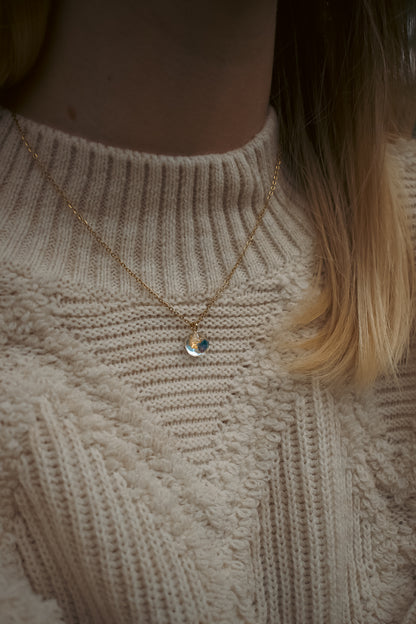 CH Design blue real flower necklace on a textured cream sweater