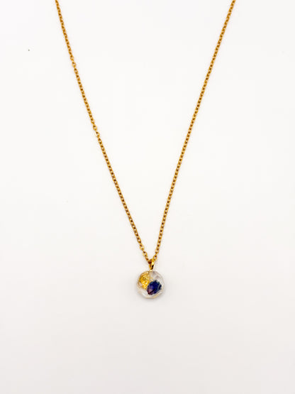 Gold necklace with a small pendant on a white background
