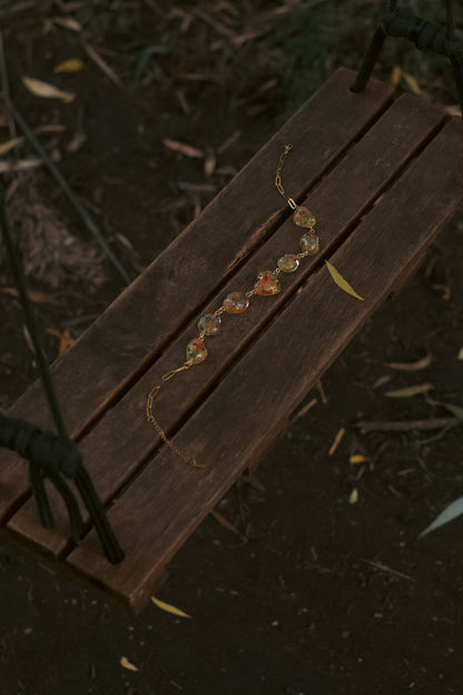 A swing with a statement necklace with pendants shaped like pebbles containing real flowers.