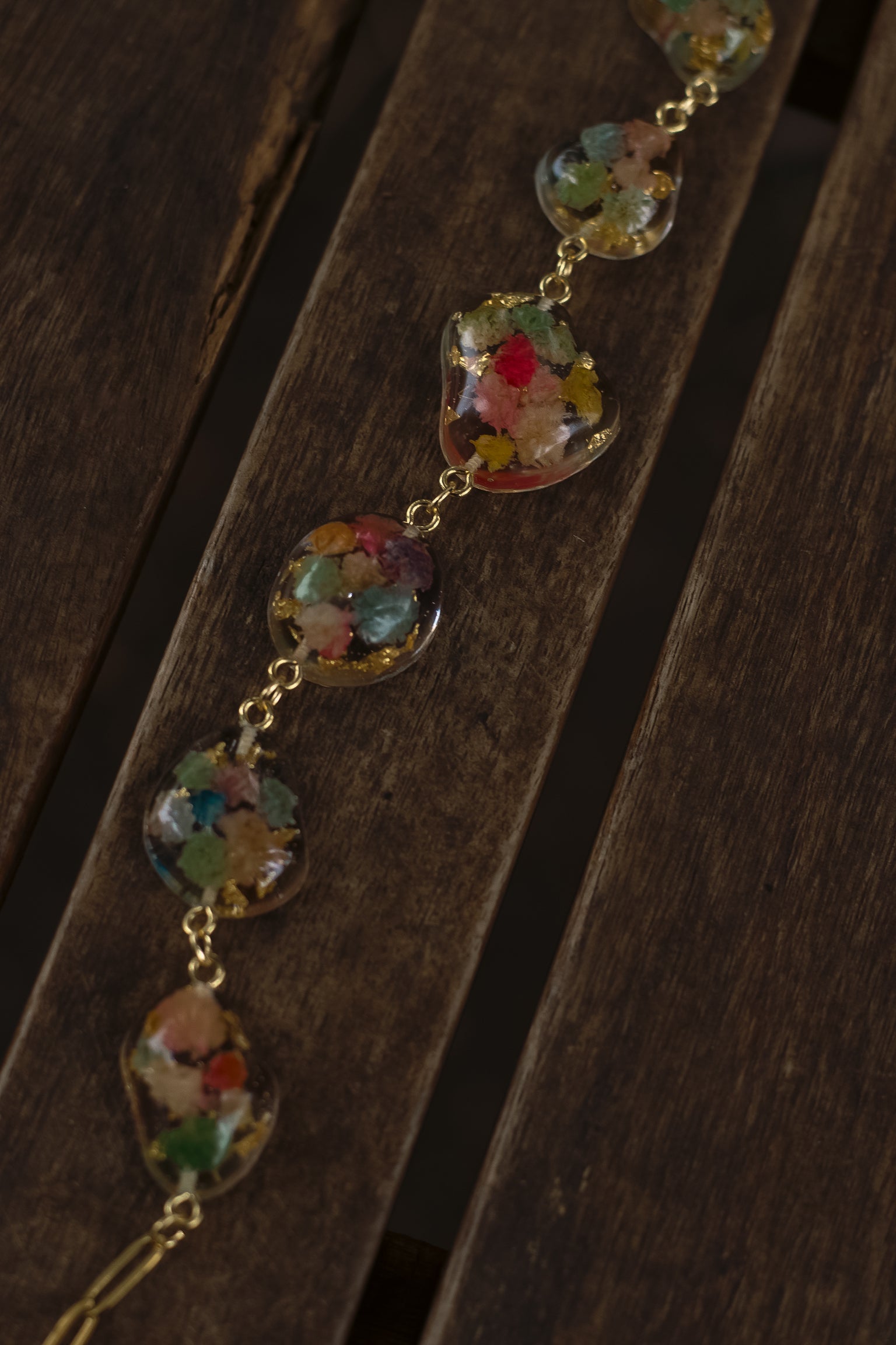 Necklace with colorful floral beads on a wooden surface