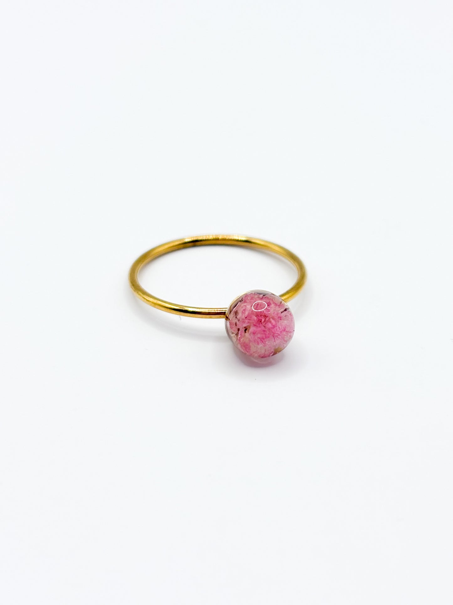 Gold ring with a pink gemstone on a white background
