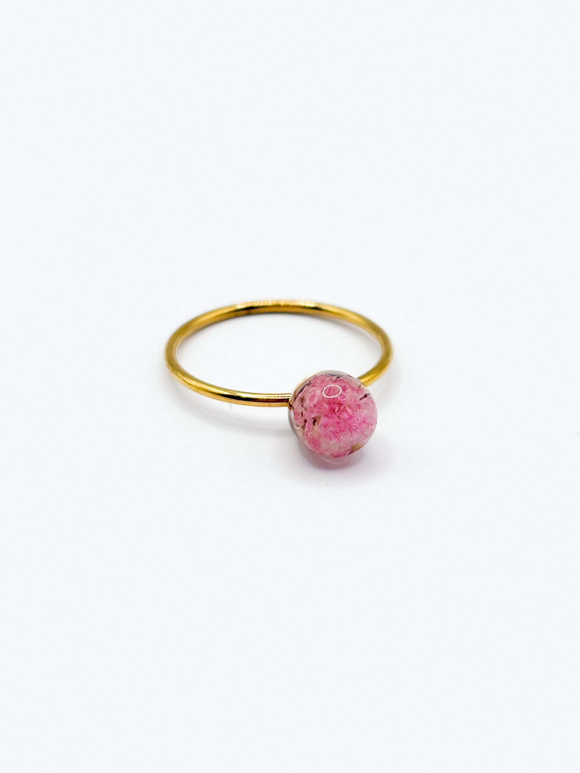 Gold ring with a pink gemstone on a white background