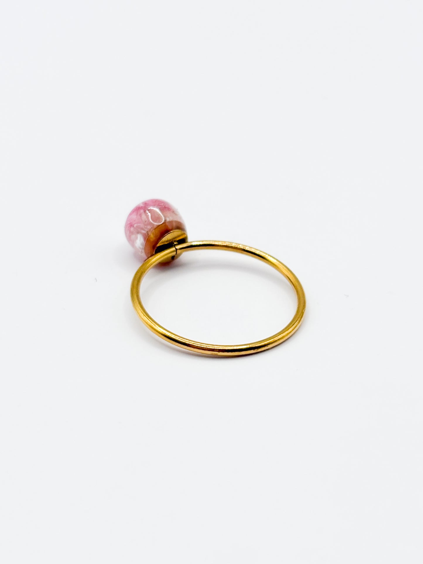 Gold ring with a pink gemstone on a white background