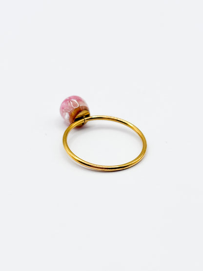 Gold ring with a pink gemstone on a white background