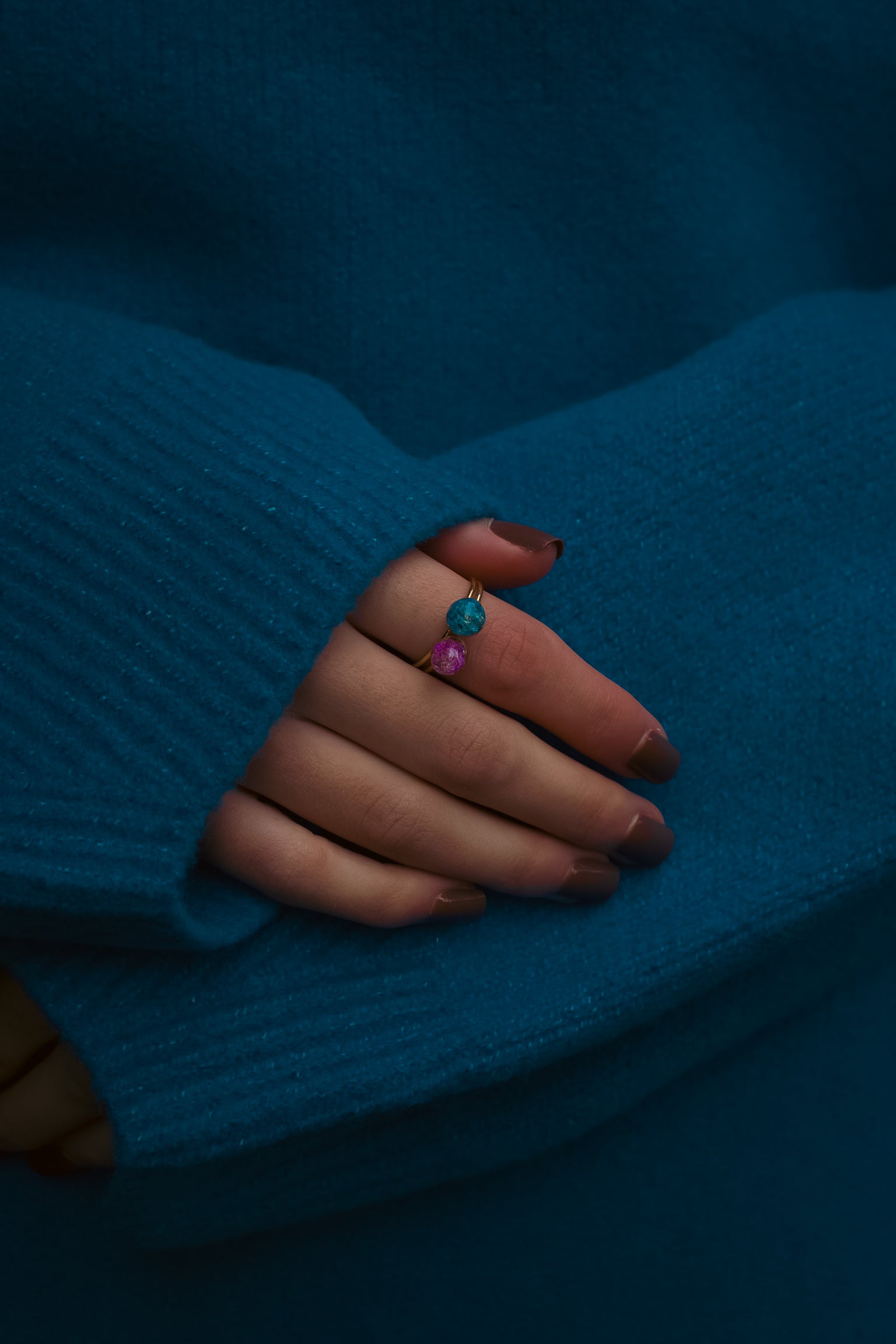 Hand with 2 real flower rings wearing a blue sweater