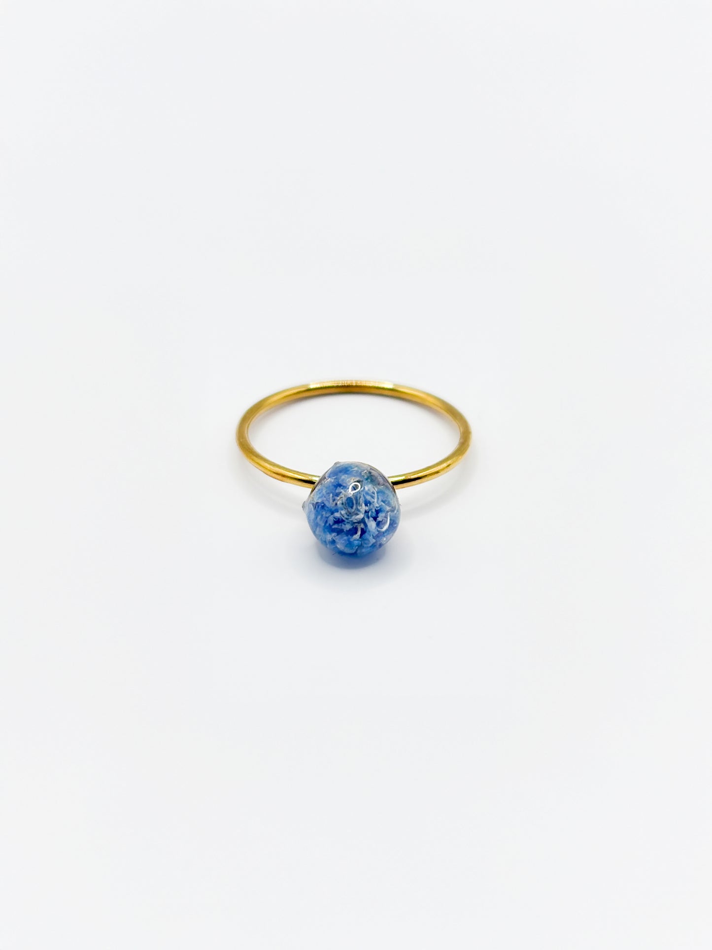 Gold ring with a blue flower on a white background