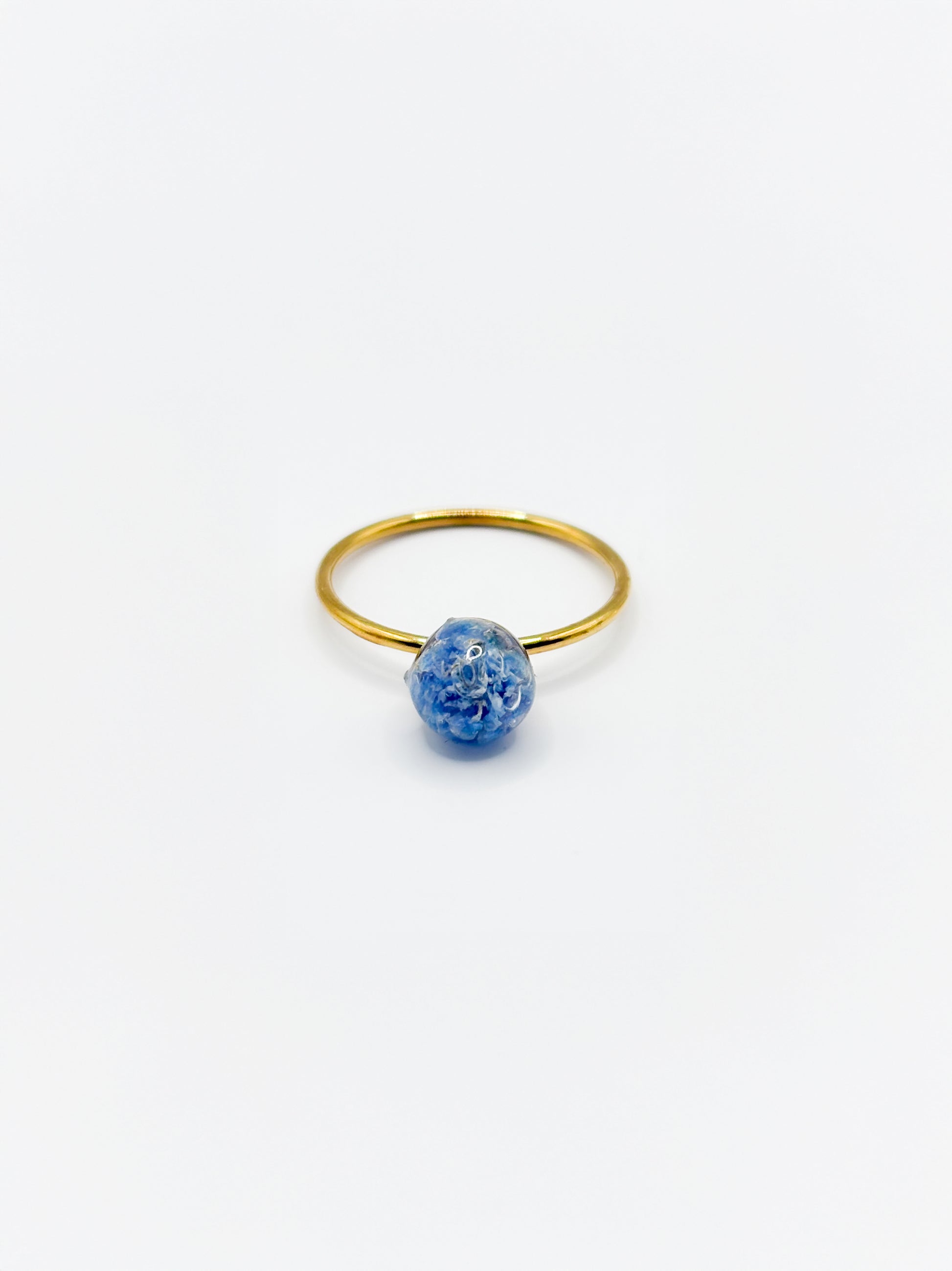 Gold ring with a blue flower on a white background