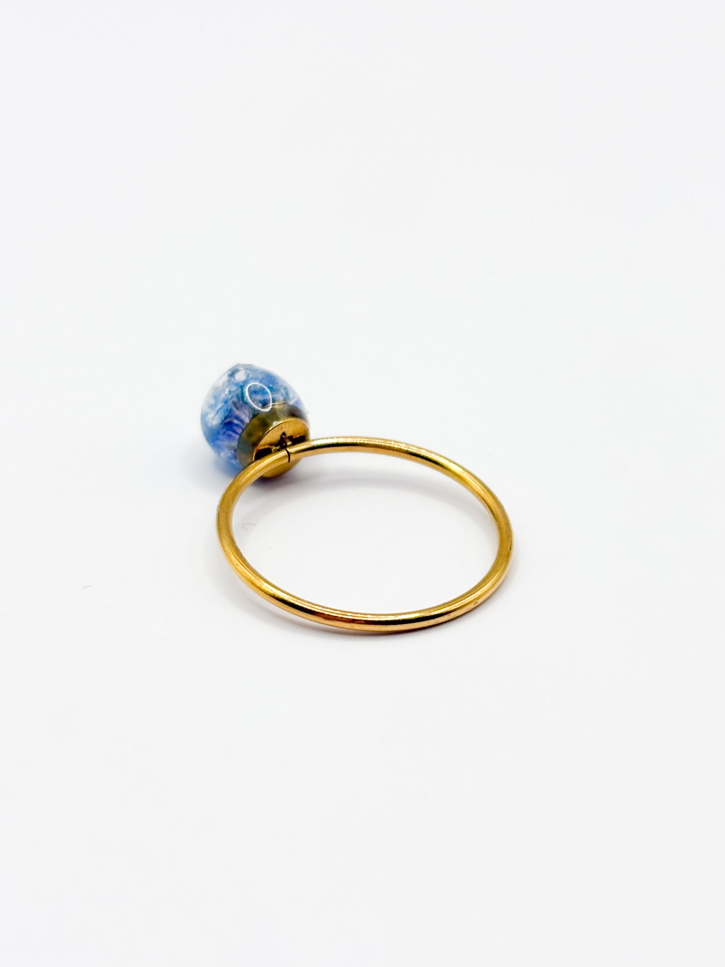 Gold ring with a blue flower on a white background