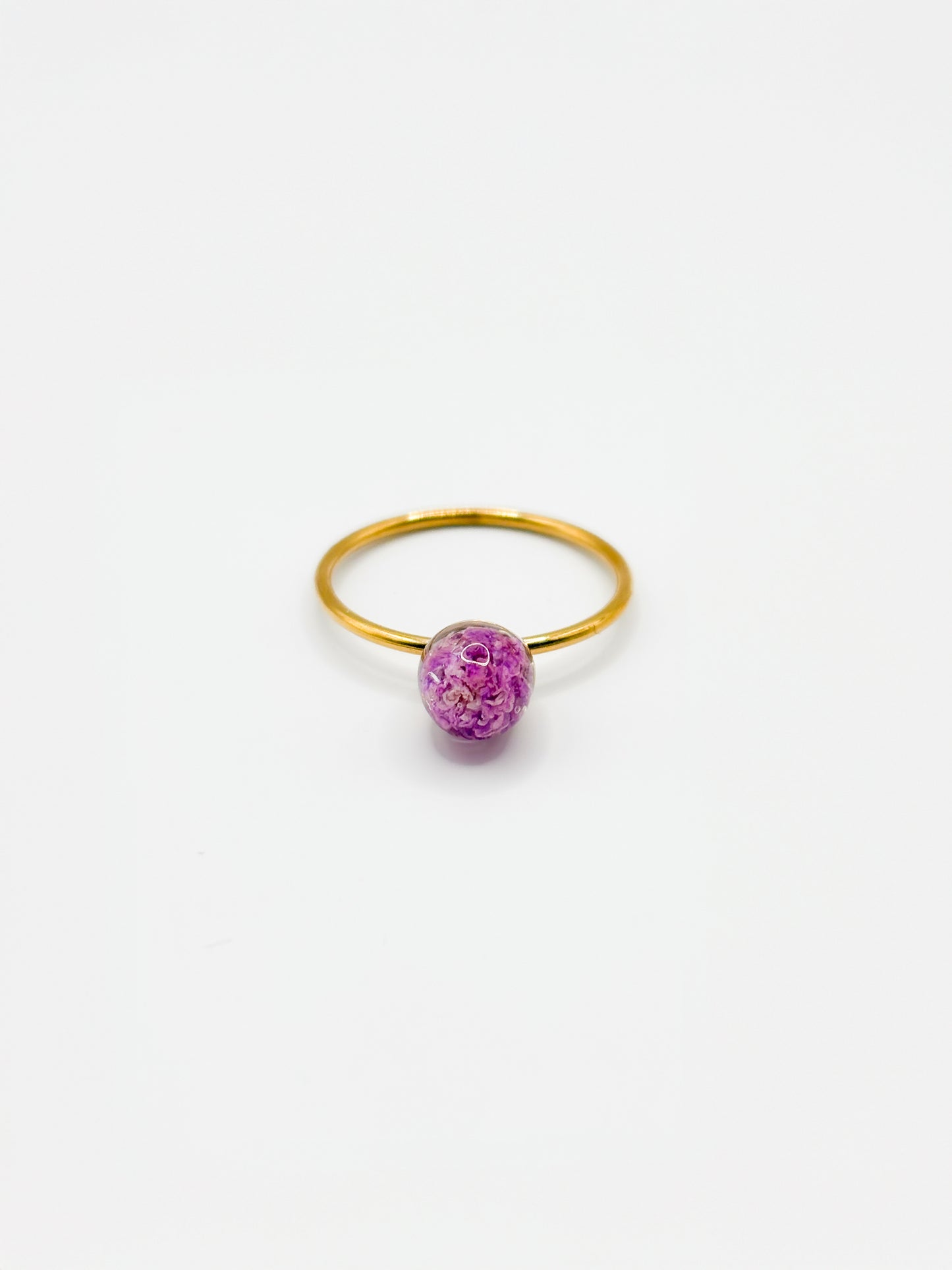 Gold ring with a purple flower on a white background