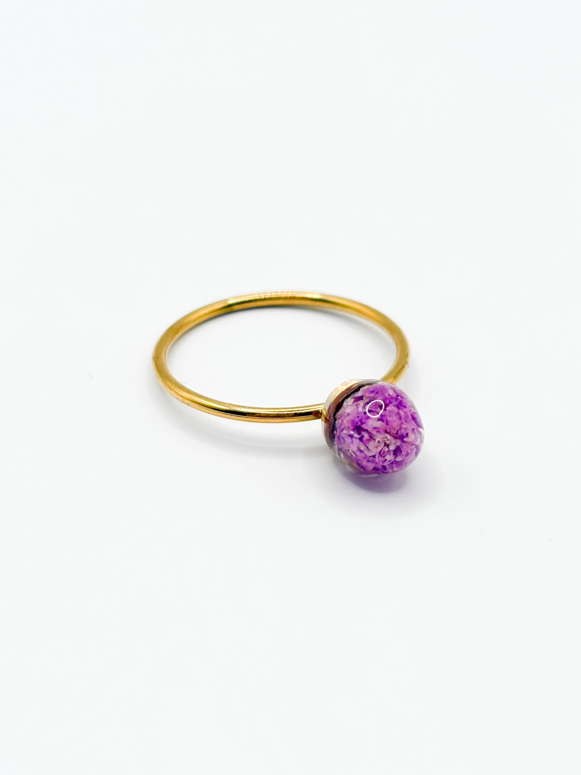 Gold ring with a purple flower on a white background